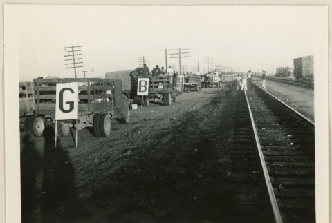 Trucks beside train tracks (ddr-densho-37-922)