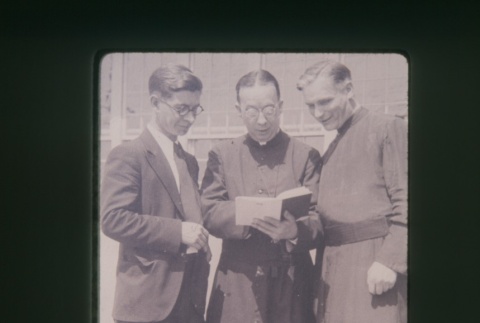 (Slide) - Image of priests looking at book (ddr-densho-330-60-master-e29890c7a5)