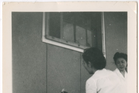 Toddler girl with two women outside barracks (ddr-densho-329-1344)