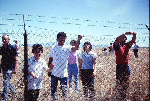 Pilgrims examining a barbed wire fence at Tule Lake (ddr-densho-294-54)