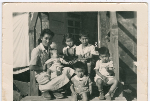 Woman sitting with five children on barracks steps in Minidoka (ddr-densho-543-6)