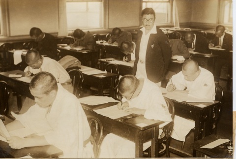 Men writing in a classroom and women sewing in a classroom (ddr-njpa-6-26)