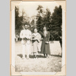 Photo of two women and a man standing in field (ddr-densho-341-65)