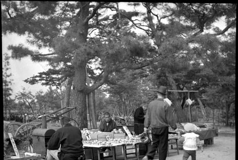 Man and child walking by small market stand (ddr-densho-426-276)