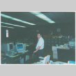 Dave Sato standing in office (ddr-densho-426-1212)
