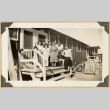 Group poses on the steps of the Kikawa barrack (ddr-densho-542-407)