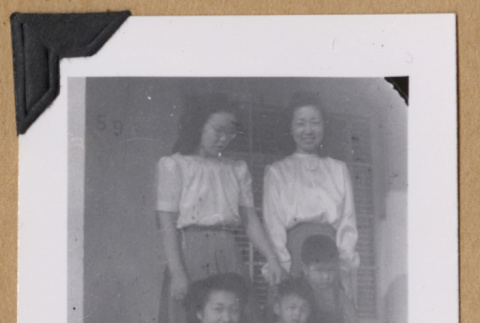 Women with two children on a porch (ddr-densho-542-312)