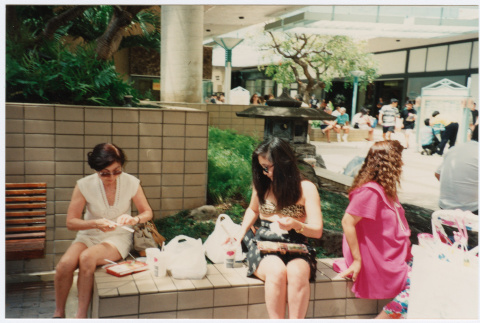 Tomi Iino and young woman eating food outside shopping center. (ddr-densho-368-315)