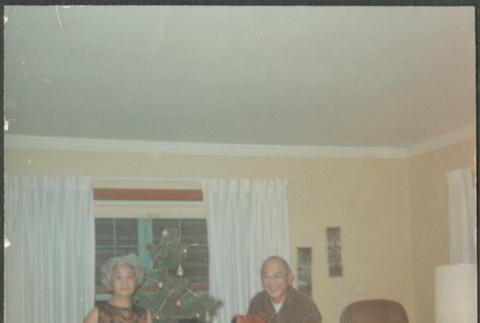Chester and Agnes Sakura with man by Christmas tree holding presents (ddr-densho-523-466)