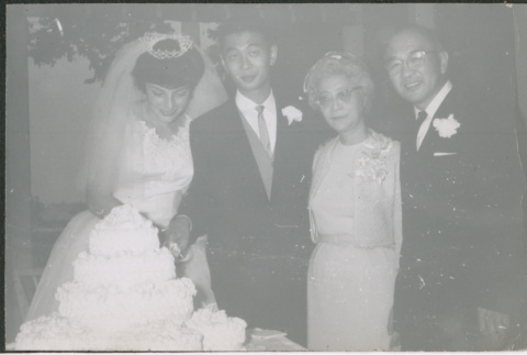 Bride and groom cutting cake with groom's parents Agnes and Chester Sakura (ddr-densho-523-350)