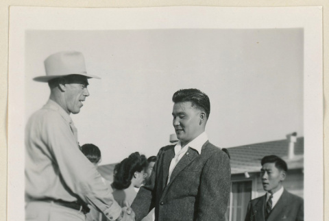 Takeo Kasawatsu shakes hands with another man (ddr-densho-37-924)