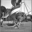 Two girls on corkscrew slide in park (ddr-densho-426-960)