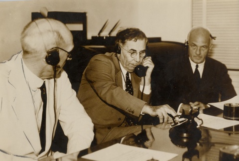 A group of men wearing headphones at a table (ddr-njpa-2-864)