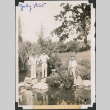 Three men standing on rocks next to pond in Japanese Garden (ddr-densho-483-561)