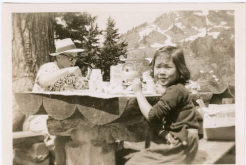 Pauline (Otani) Shigaki and Seigo Otani sitting at picnic table (ddr-densho-467-7)