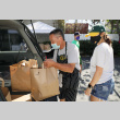 Man and woman loading food bags into car (ddr-densho-512-70)