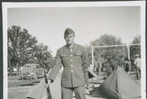 Man with rifle next to tents (ddr-densho-434-464)