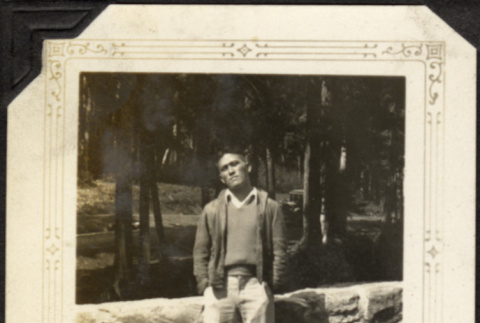 Man standing by stone wall (ddr-densho-326-486)