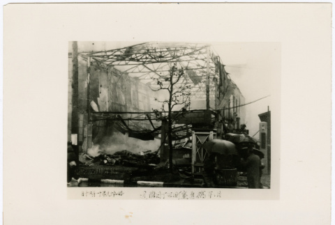 Onlookers stand outside the shell of a burned out building (ddr-densho-381-69)