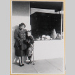 Woman with boy on crutches outside shop (ddr-densho-522-26)