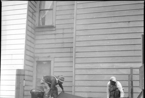 Two men laying tar paper on roof (ddr-densho-426-2159)