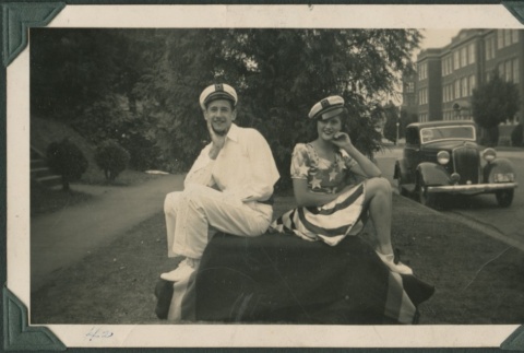 Young man and woman pose on draped table (ddr-densho-321-18)