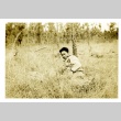 Soldier laying in a field (ddr-densho-22-228)