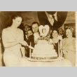 Eleanor Roosevelt slicing a cake celebrating Franklin D. Roosevelt (ddr-njpa-1-1538)
