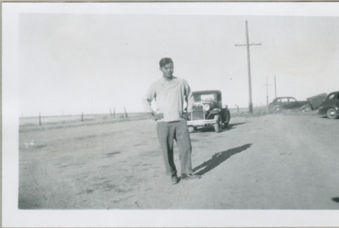 A man standing in front of a car (ddr-densho-300-116)