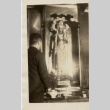 A man standing in front of a religious [?] statue (ddr-njpa-8-5)