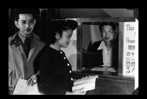 Henry Tsuno and Helen Akahoshi in the cashier office, Amache Co-op (ddr-csujad-55-1551)