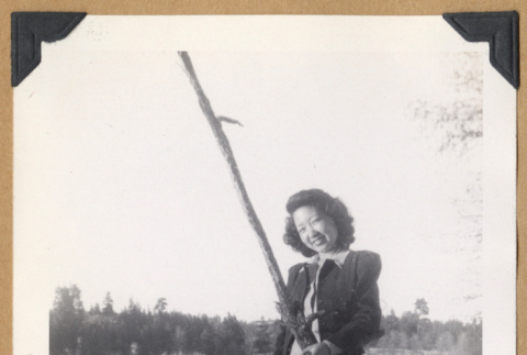 Woman poses on a fallen tree (ddr-densho-542-325)