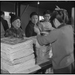 Japanese Americans purchasing camp newspaper (ddr-densho-37-458)