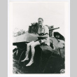 David Quaid sitting on a tank (ddr-densho-1007-332)