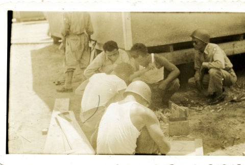 Soldiers leaning over a project (ddr-densho-22-211)