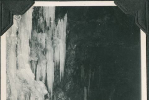 Man standing at entrance to tunnel by icicles (ddr-ajah-2-323)