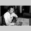 Frank S. Emi with newspaper (ddr-densho-1007-1163)