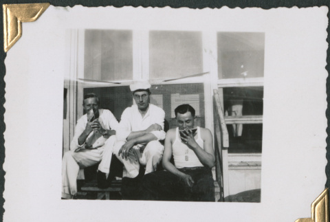 Three men sitting on steps eating (ddr-densho-434-226)