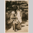 Young woman standing by seated woman (ddr-densho-426-1561)