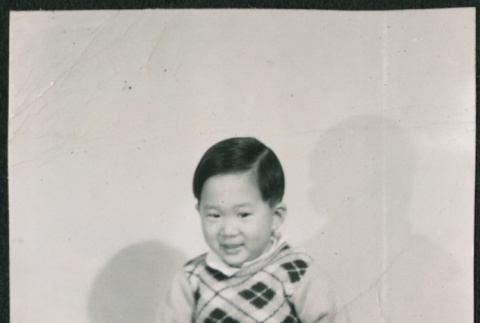 Child sitting on stool covered in a blanket (ddr-densho-523-240)