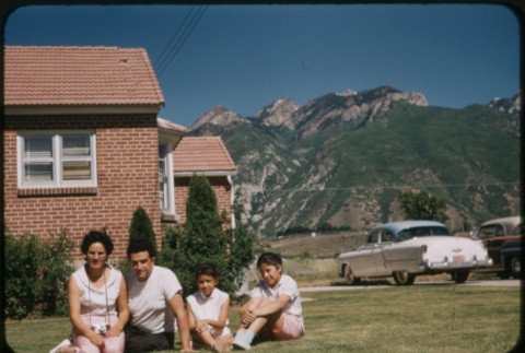 A family sitting on the lawn of a house (ddr-densho-338-501)