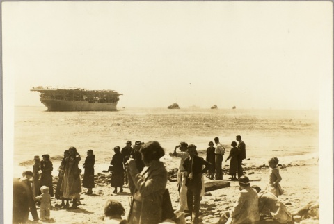 A crowd watching the USS Langley from a beach (ddr-njpa-13-78)