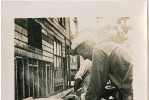 Man using circular saw (ddr-densho-426-1957)