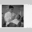 Dentist, Dr. T. Nakamura, working on a patient's teeth (ddr-fom-1-856)