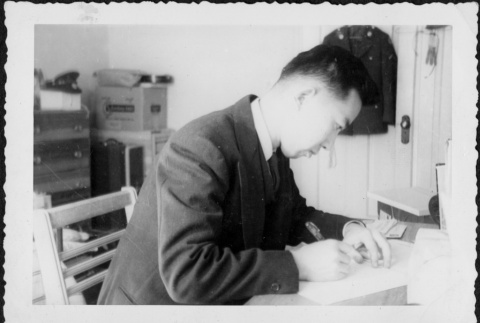 Man sitting at desk writing (ddr-densho-434-378)
