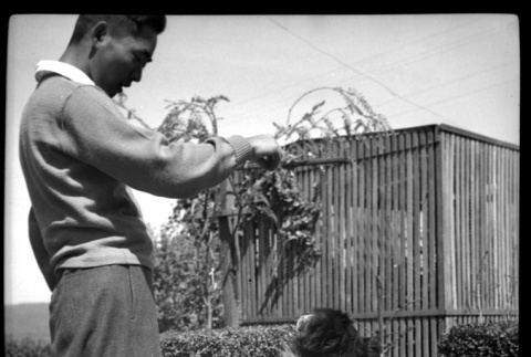 Frank Miwa with dog doing trick (ddr-densho-475-82)