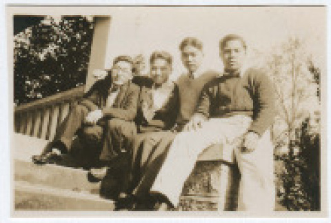 Four young men sitting on porch (ddr-densho-383-404)