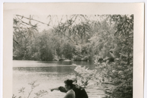 Two people on riverbank, one pointing (ddr-densho-377-1767)