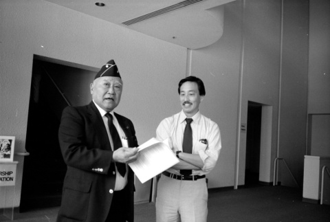 Two men leafing through papers (ddr-densho-1007-554)
