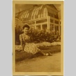 Miyo Kusunoki sitting in front of a greenhouse (ddr-manz-6-107)